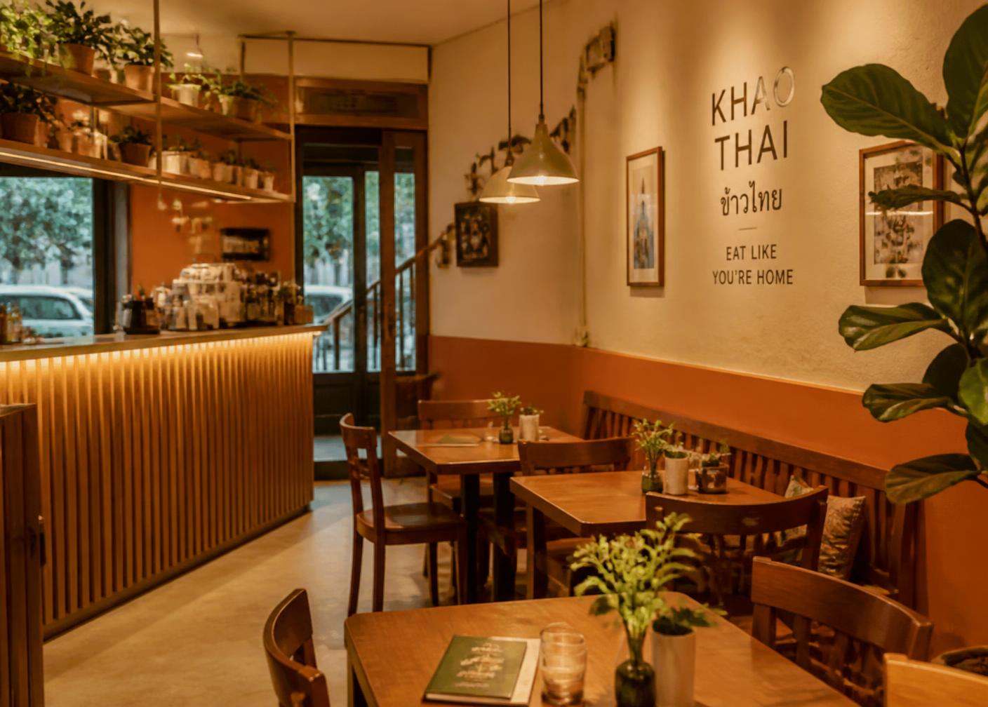 Salle du restaurant MYTHAI, tables en bois et lumière chaude